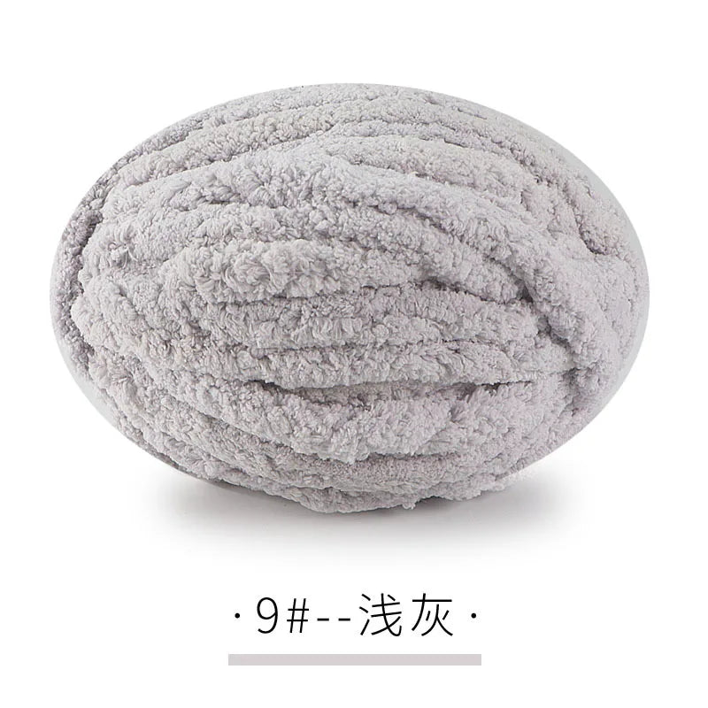 A ball of light gray chunky chenille yarn for hand knitting projects.