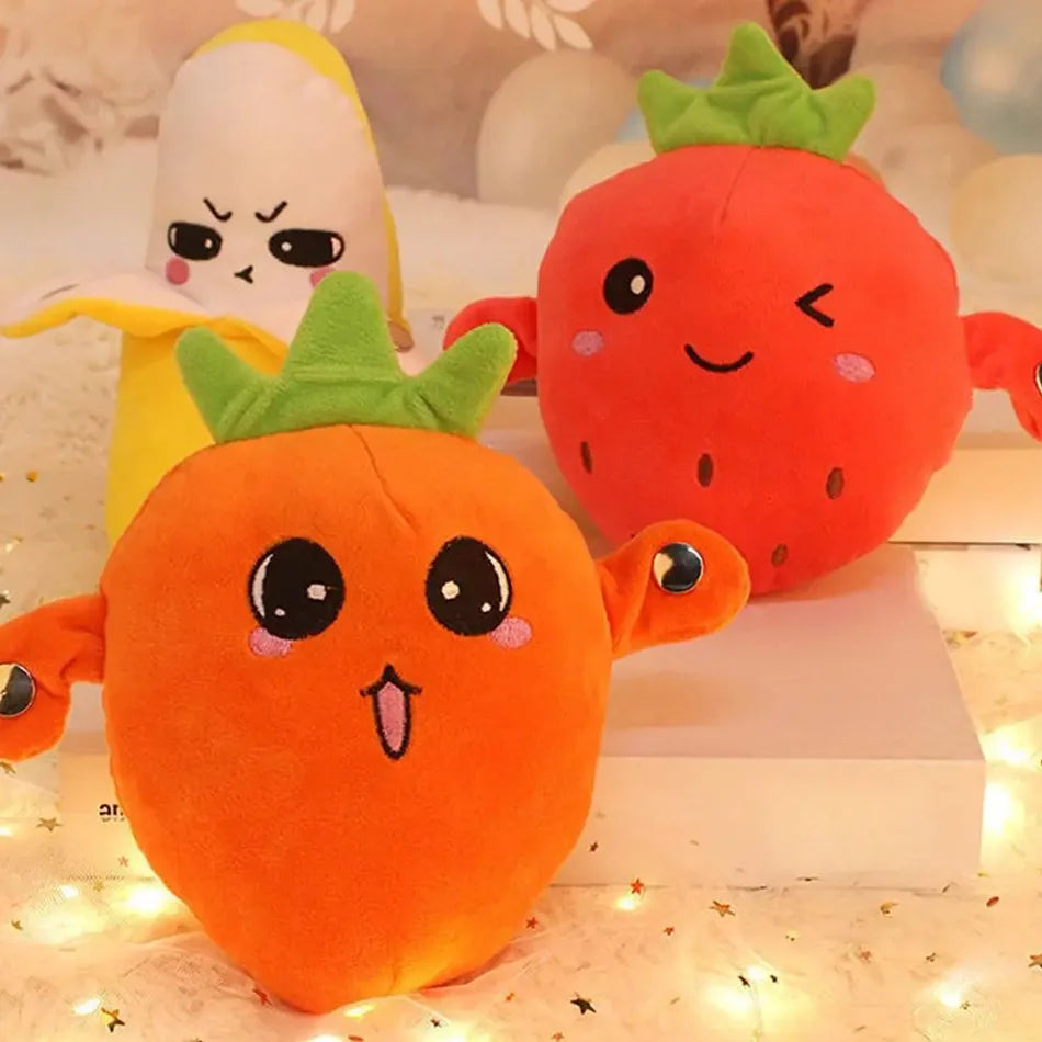 An orange and red strawberry plush toy with green leaves sitting on a white surface.