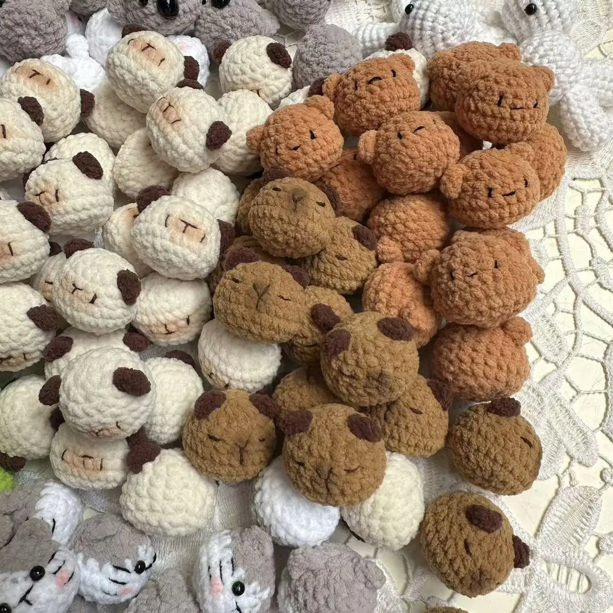 A collection of handcrafted crochet animal keychains in various shades of brown, beige, and white.