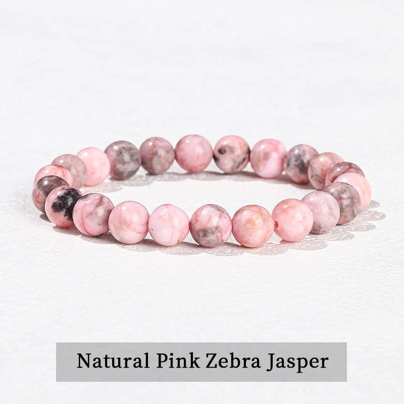 A bracelet made of natural pink zebra jasper beads, showing various shades of pink and gray.