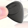 A close-up of a black guitar pick with an anti-slip grip, held between fingers.