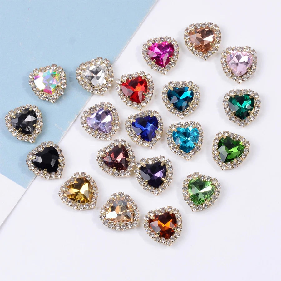 A collection of heart-shaped flatback sew-on rhinestones in various colors and clear stones scattered on a white background.