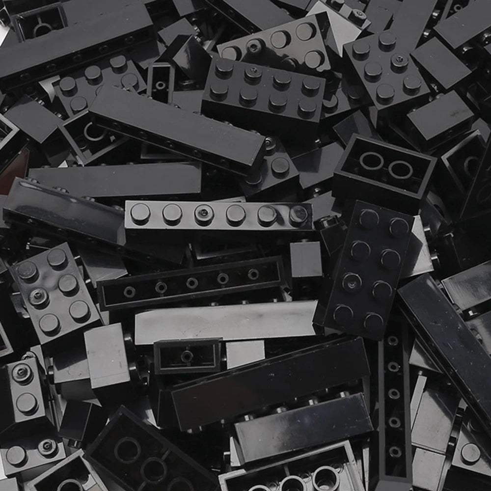 A pile of black building blocks and construction pieces for creative DIY projects.
