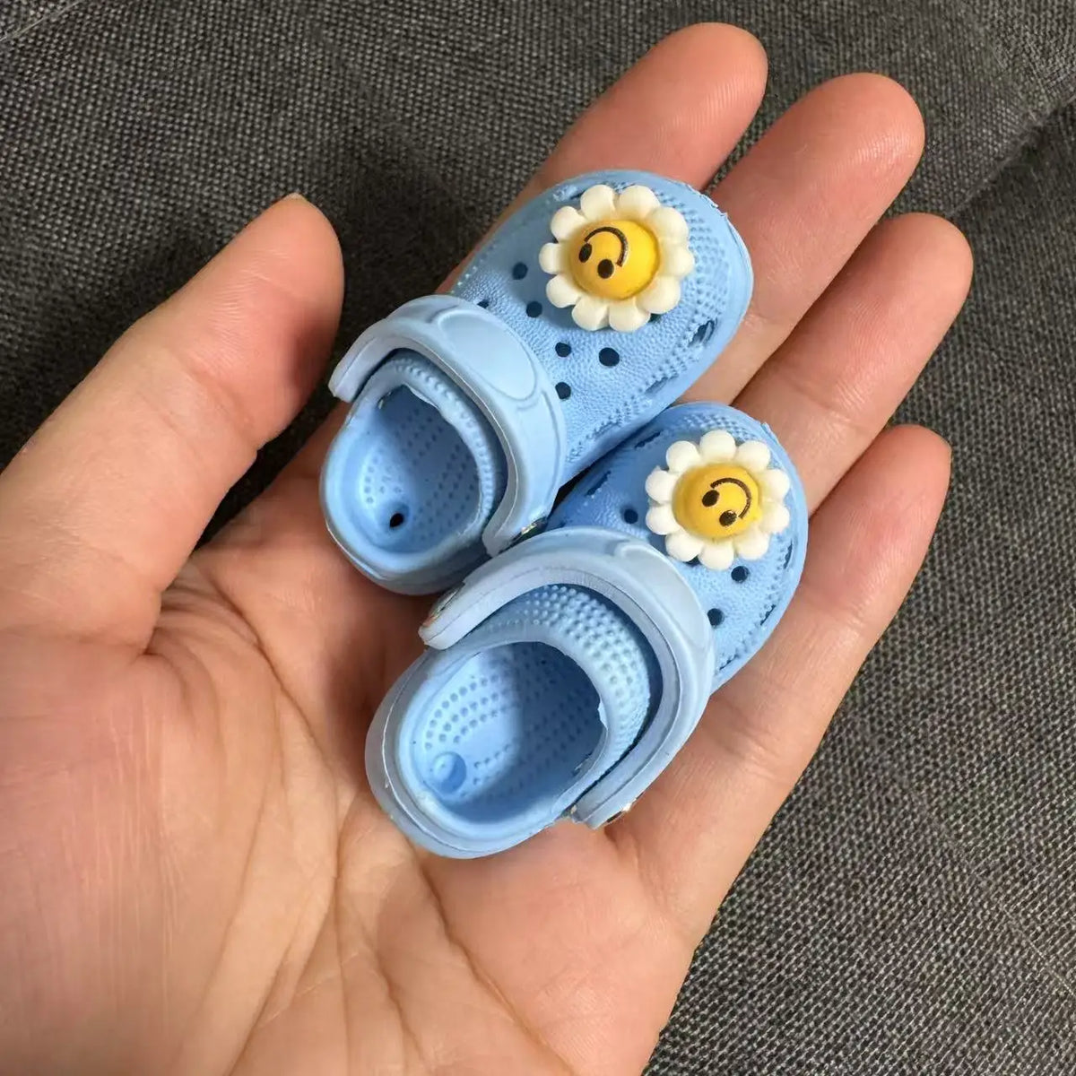 Pair of light blue fashion slippers for dolls decorated with yellow daisy flowers