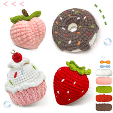 A set of crochet items including a pink apple, a dark chocolate donut, and a red strawberry.