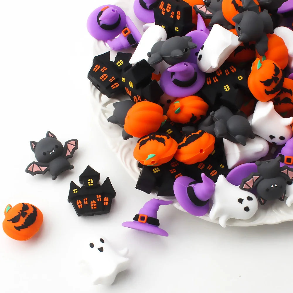 A collection of Halloween silicone beads featuring 3D bat and pumpkin shapes in black, orange, purple, and white.