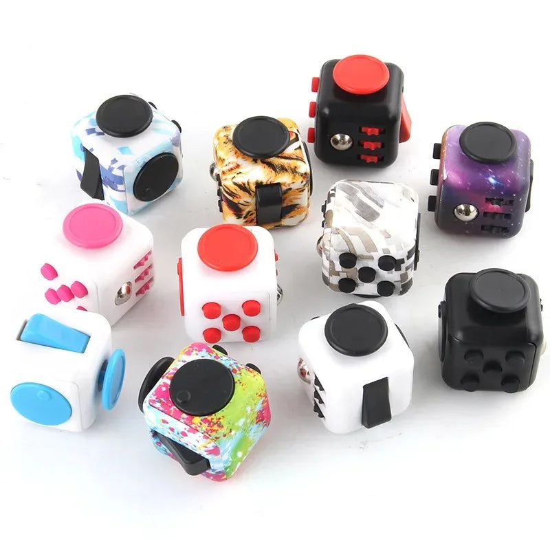 A collection of colorful fidget cubes with rotating joysticks and magnetic buttons in various patterns and colors.