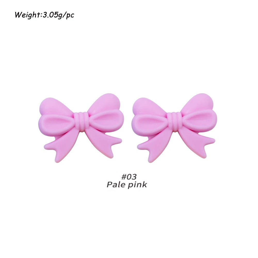 Pair of pale pink silicone bow tie beads for jewelry making and craft projects