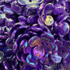 Close-up of deep purple acrylic beads shaped like four-petal flowers for jewelry making