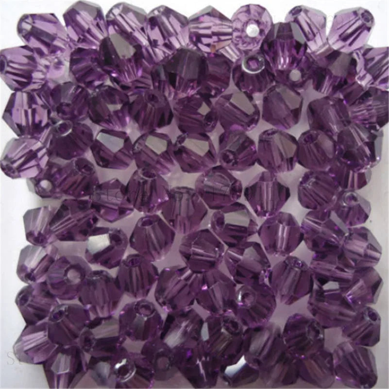 Gros plan de perles de cristal violettes facettées utilisées pour la fabrication de bijoux DIY.