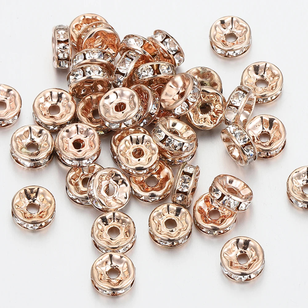 A pile of rose gold crystal rondelle spacer beads for jewelry making.