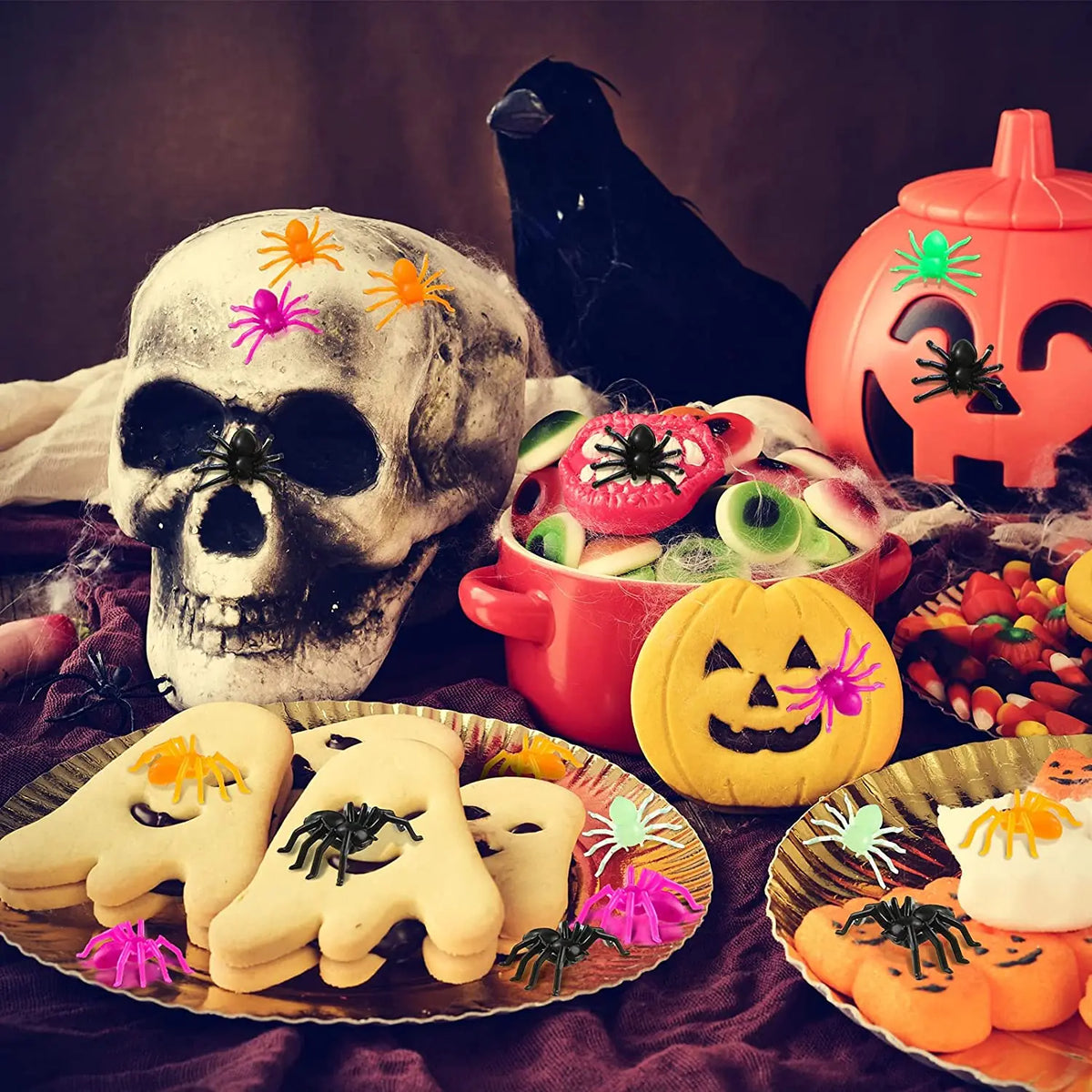 A pumpkin-themed display featuring a skull, realistic fake spiders, and Halloween decor.