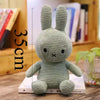 A light green Miffy plush toy rabbit with a textured body is shown next to a measuring scale.