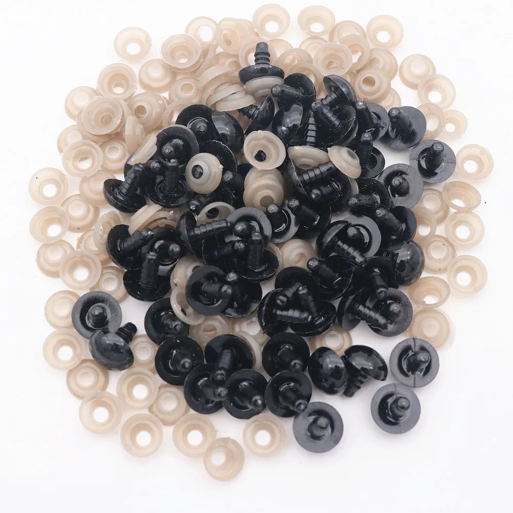 A pile of black plastic safety eyes and white washers for crafting projects