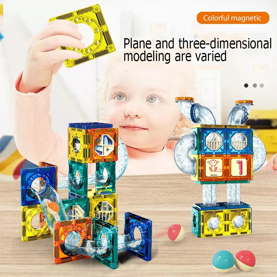 A child is building a structure with colorful magnetic pipe blocks on a wooden table.