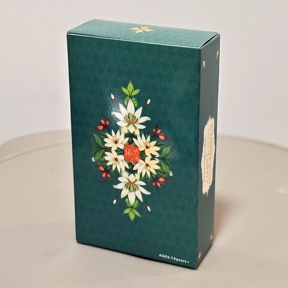 A dark teal box for a Woodland Fairy Tale Tarot Deck featuring white and red floral illustrations.