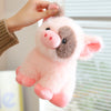 A pink and gray plush pig stuffed animal being held by a hand.