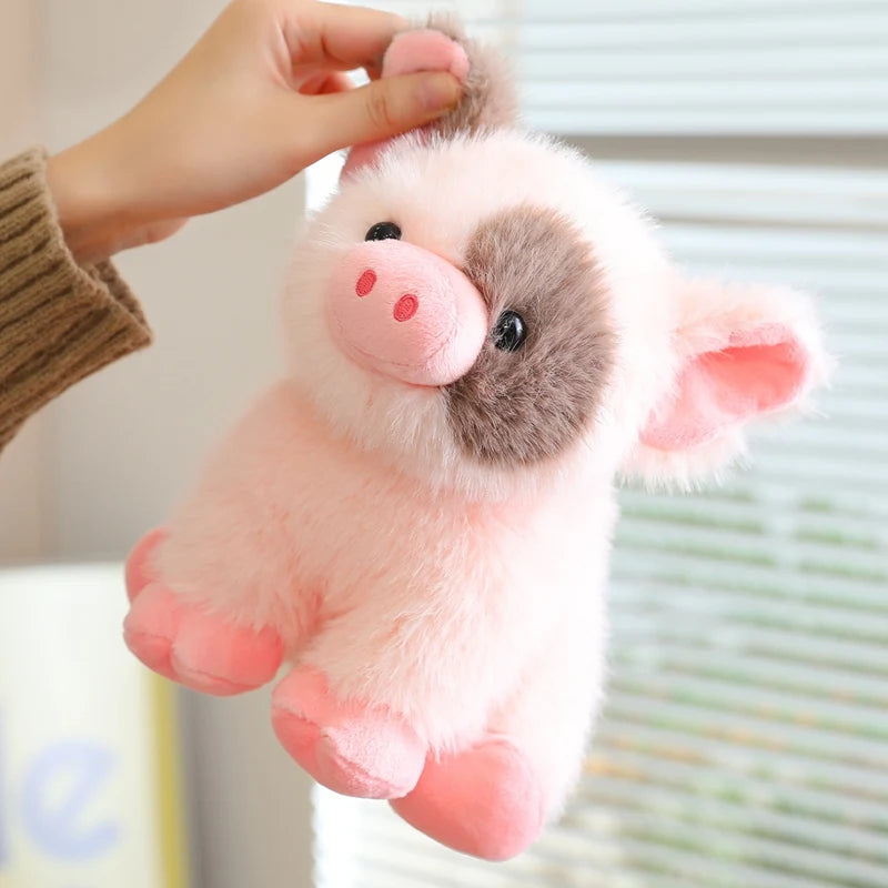 A pink and gray plush pig stuffed animal being held by a hand.