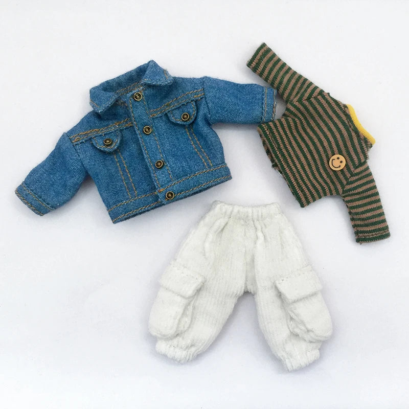 A set of miniature clothing including a denim jacket, a striped shirt, and white pants for doll play.