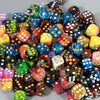 A pile of ten multi-colored acrylic D6 dice in various colors and patterns.