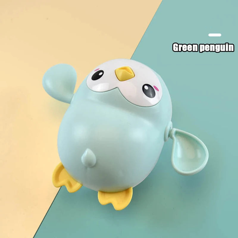 A light blue penguin bath toy with yellow feet and a yellow beak is shown against a teal background.