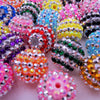 A close-up view of a pile of mixed two-tone striped resin beads in various colors like pink, purple, yellow, and blue.