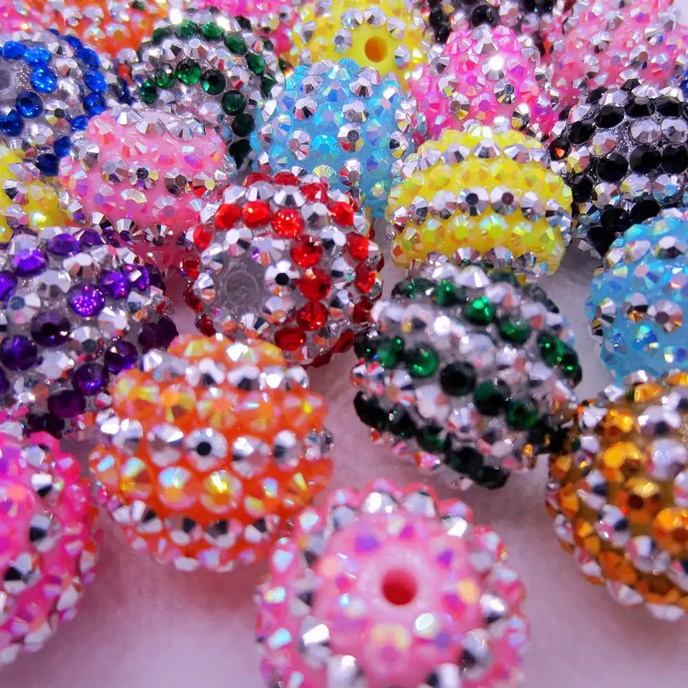 A close-up view of a pile of mixed two-tone striped resin beads in various colors like pink, purple, yellow, and blue.