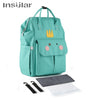A teal waterproof diaper backpack with a zipper, featuring a changing mat and stroller straps.