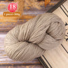 A ball of beige premium alpaca blend yarn used for knitting or weaving, shown on a wooden surface.