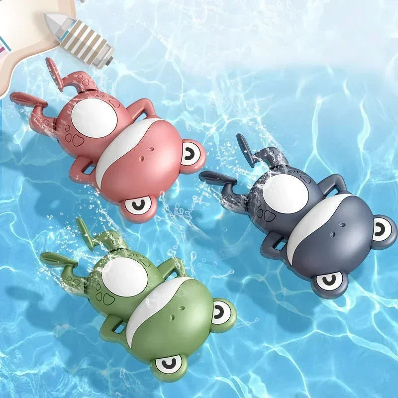 Ein Set aus drei süßen mechanischen Fisch-Badetieren in rosa, grau und grün, die in klarem Wasser schwimmen.
