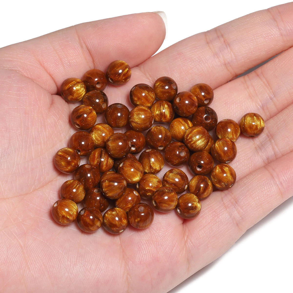 A handful of glossy, reddish-brown tiger eye resin beads for jewelry making.