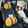 Two yellow and brown bee plush lumbar support pillows are placed on the seats of a car.