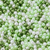 A close-up of small, round imitation pearl beads in shades of green and white.