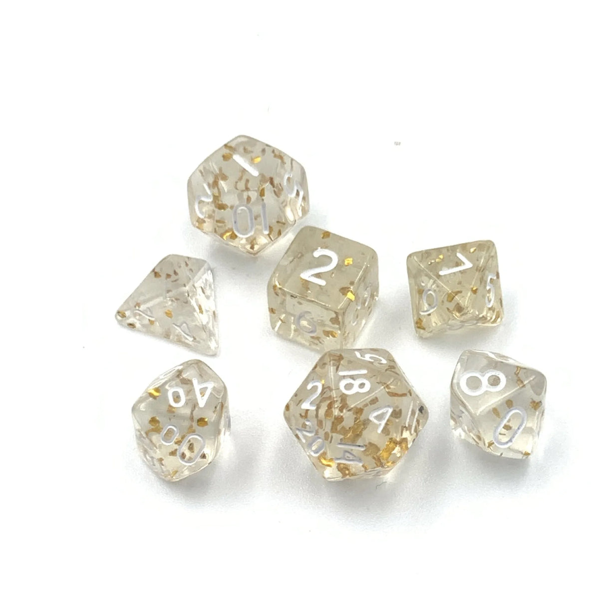 A collection of seven transparent acrylic dice, numbered 1 through 8, scattered on a white surface.