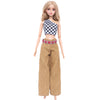 A fashion doll wearing a checkered crop top and loose brown pants with a patterned belt.