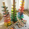 A wooden sensory music tree with a marble run featuring colorful, layered discs.
