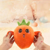 An orange fruit plush toy with a face and green leaves is being held by hands.