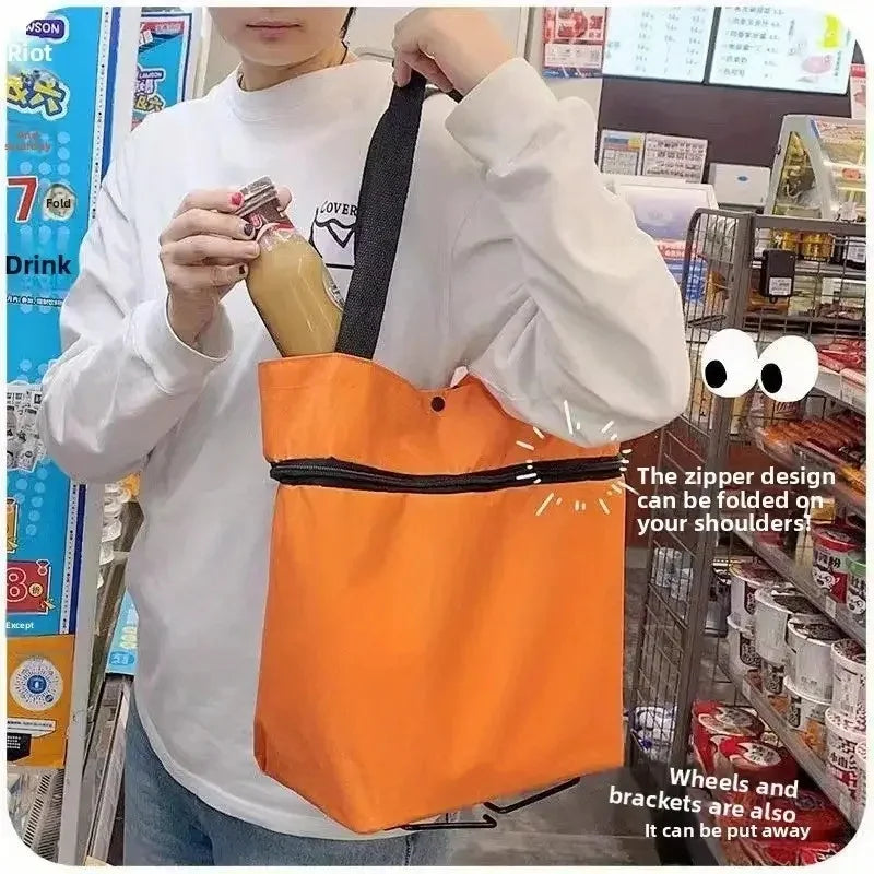 A person holds an orange fabric shopping bag with a black strap, demonstrating its foldable design.