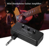 A black mini headphone guitar amplifier is shown next to a person playing a guitar.