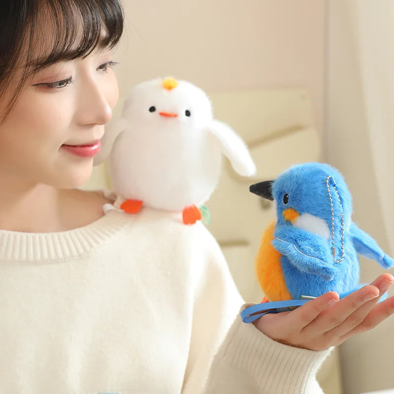 A woman is holding a white cartoon bird plush toy, resembling a penguin or snowbird, in her hand.