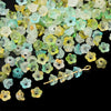 A pile of gradient bellflower acrylic beads in shades of green, yellow, and white for jewelry making