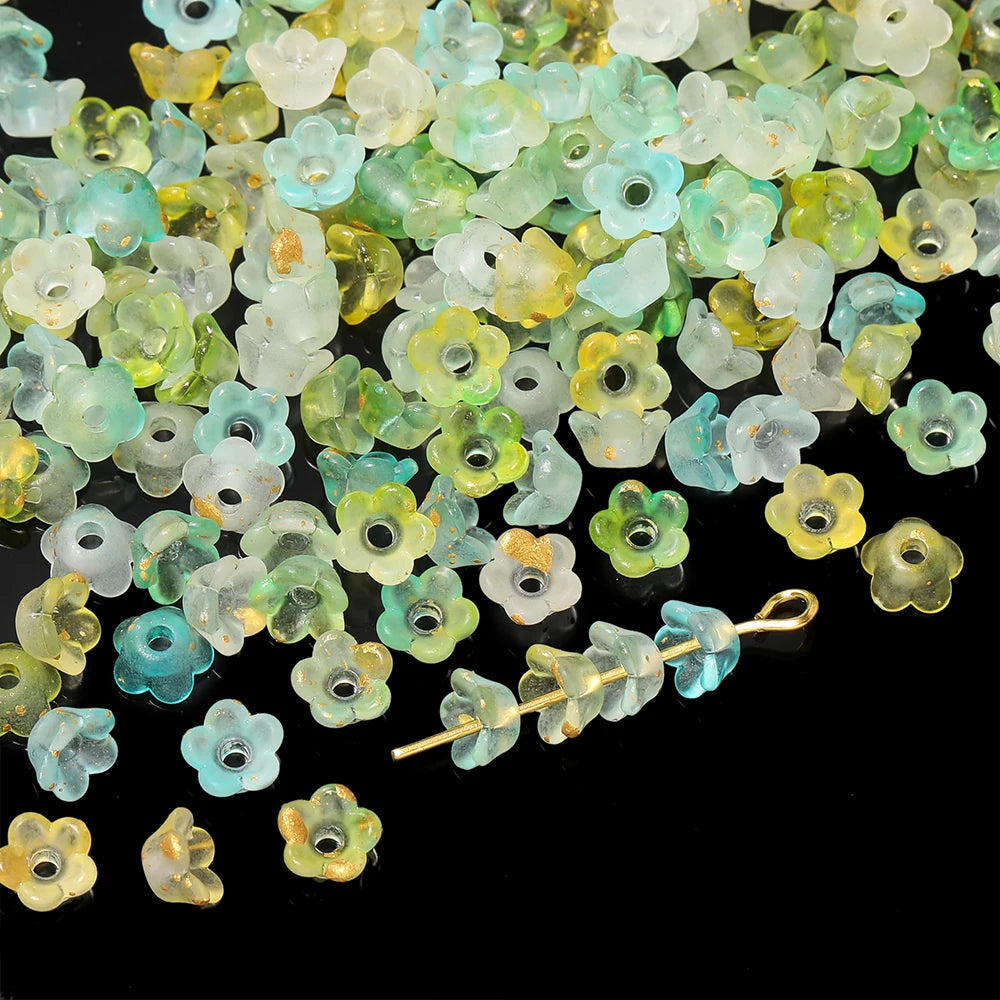 A pile of gradient bellflower acrylic beads in shades of green, yellow, and white for jewelry making