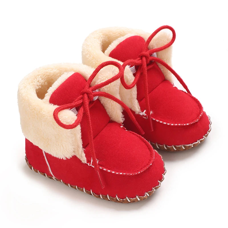 Pair of red plush baby snow boots for girls and boys with white faux fur trim