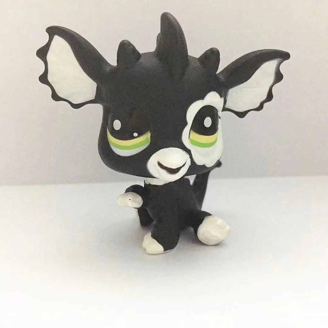 A black and white Littlest Pet Shop style standing dog figure with large ears and green accents.