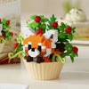 A building block set depicting a fox face with green leaves and red berries arranged in a yellow cup.