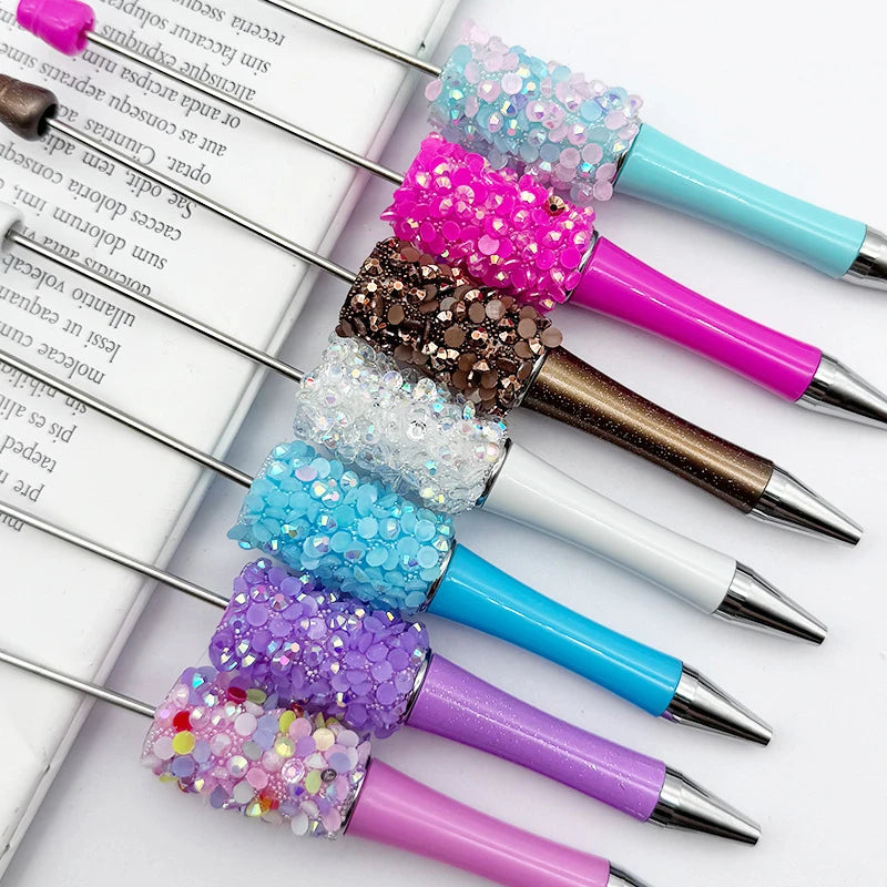 A collection of 12 pack diamond sequin bead ballpoint pens in various shades of pink, purple, and blue.