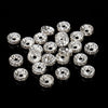 A collection of silver crystal rondelle spacer beads for jewelry making arranged on a black surface.