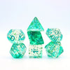 A set of green crystal style polyhedral dice, including a tetrahedron and dodecahedron, displayed on a white background.