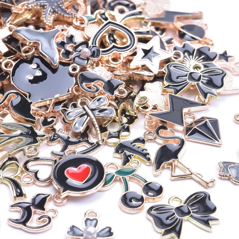 Assortment of gold-tone enamel charms for jewelry making featuring various shapes and designs