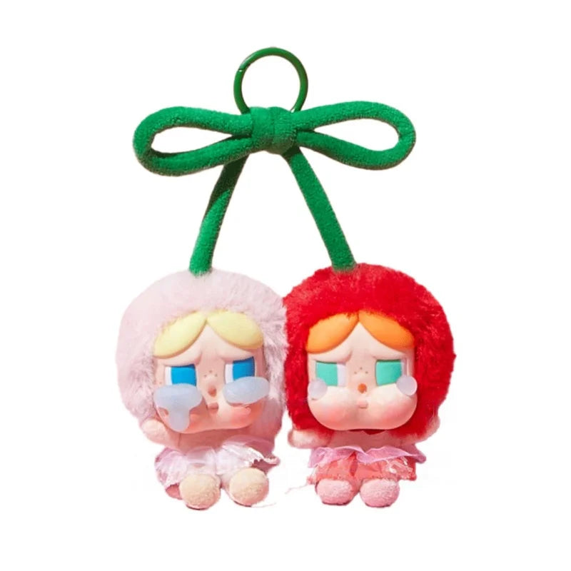 A blind box featuring two chibi-style vinyl figures with pink and red hair and blue eyes, suspended by a green ribbon.